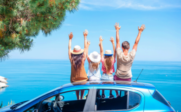 Familia celebrando una meta junto a su automóvil