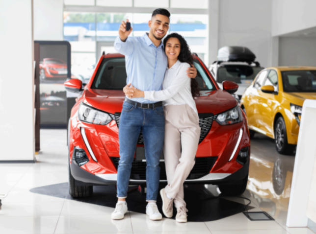 Pareja celebrando la compra de un automóvil